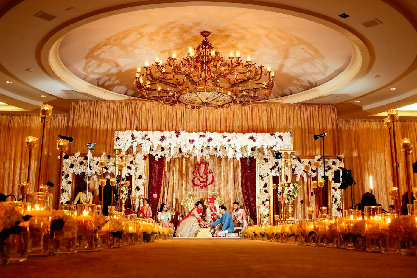 A decorated banquet hall stage with guests seated for the evening