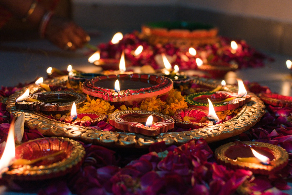 Lit clay lamps and marigolds on a festival tray